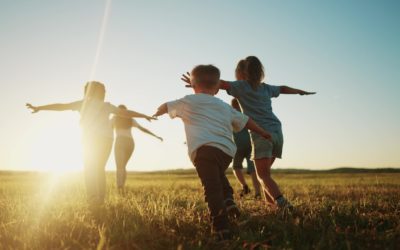 kids run in the park at sunset. friendly family children camp kid dream concept. a group of children run on the grass at rays fun of the sun silhouette. childhood dream teamwork sunset concept