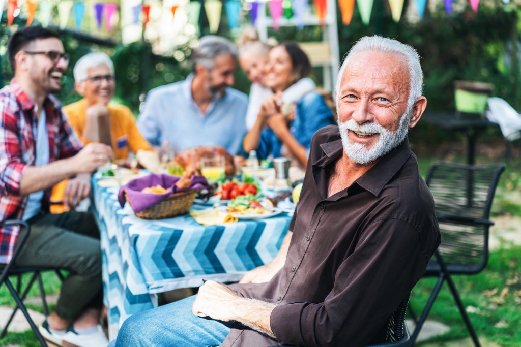 Man smiling at camera with guests in the background (1)